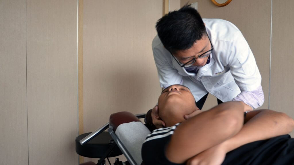 Doctor providing patient sports injury chiropractic treatment