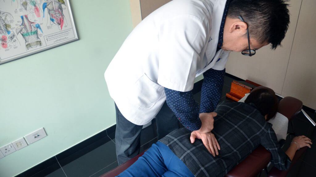 Chiropractor treating patient for spine pain