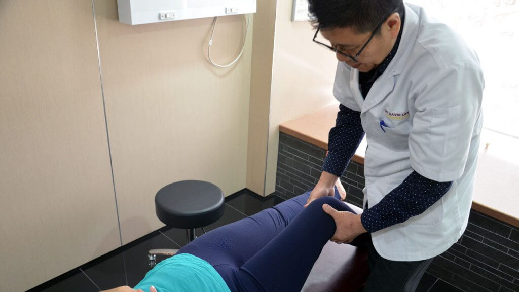 Chiropractor providing patient knee joint and knee pain treatment